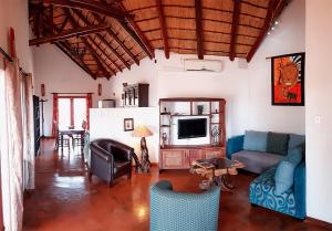 a living room with a couch and a tv at Yingwe self catering villa bordering Kruger with private pool in Phalaborwa