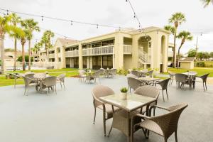 a patio with tables and chairs in front of a building at A & S Vacation Rooms in Kissimmee