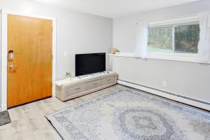 an empty living room with a television and a door at The Bear Hug in Eagle River