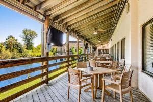 a patio with tables and chairs on a deck at HH Beach & Tennis 322B in Hilton Head Island