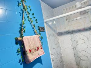 Toca da Mona Roots Hostel في فيتوريا: حمام مع منشفة معلقة من الجدار