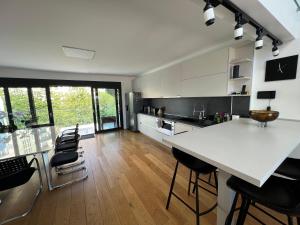 cocina con encimera blanca grande y sillas en Grand Appartement de standing Rooftop Jacuzzi, en Malakoff