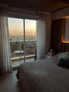 a bedroom with a bed and a large window at Departamento Moderno ,Torre Blue, Barrio Sur Tucumán in San Miguel de Tucumán