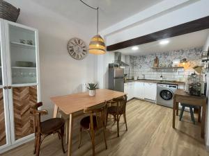 a kitchen with a wooden table and chairs in a kitchen at Casa Mariete in Villanúa