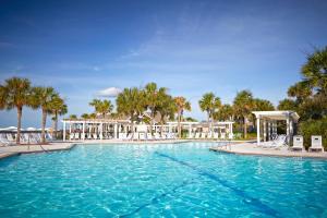 a large swimming pool with chairs and palm trees at High Hammock 171 in Seabrook Island