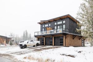 a truck parked in front of a house in the snow at 22 Sunniva by FantasticStay in Fernie