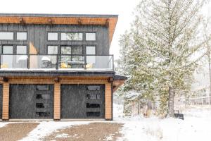 a house with a deck in the snow at 22 Sunniva by FantasticStay in Fernie