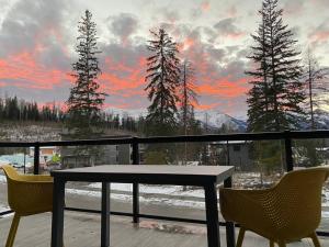 a table and two chairs on a balcony with a sunset at 22 Sunniva by FantasticStay in Fernie