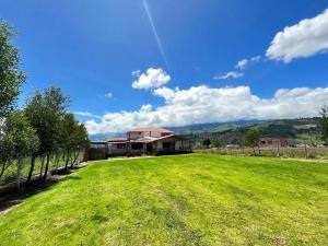 a large grassy yard with a large house at Casa de campo con hermosa vista in Riobamba
