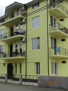 un edificio amarillo con balcones en un lateral en Villa Ureki en Ureki