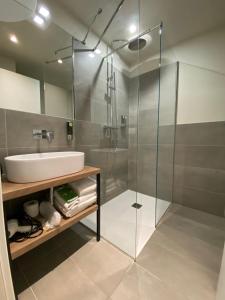 a bathroom with a glass shower and a sink at Malvezzi24 Boutique Rooms in Desenzano del Garda