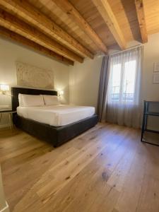 1 dormitorio con 1 cama grande y suelo de madera en Malvezzi24 Boutique Rooms en Desenzano del Garda