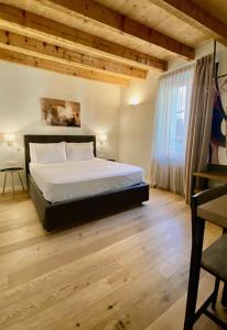 1 dormitorio con 1 cama y suelo de madera en Malvezzi24 Boutique Rooms en Desenzano del Garda