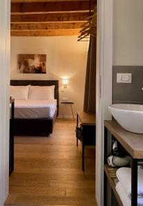 a bedroom with a bed and a bathroom with a sink at Malvezzi24 Boutique Rooms in Desenzano del Garda