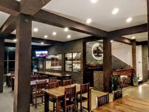 restauracja z drewnianymi stołami i krzesłami oraz bar w obiekcie World's End Base Eco-Village w mieście Belihul Oya