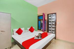 1 dormitorio con 1 cama con paredes rojas y verdes en Flagship Second Home Guest House Near Omaxe Celebration Mall en Gurgaon