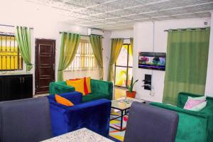 een woonkamer met kleurrijke stoelen en een tafel bij ARO (1.0) 2BD Studio Flat (Abule-Egba/Lagos) in Agege