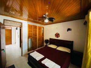 1 dormitorio con 1 cama y ventilador de techo en Casa Feliz Hostal, en Santa Marta