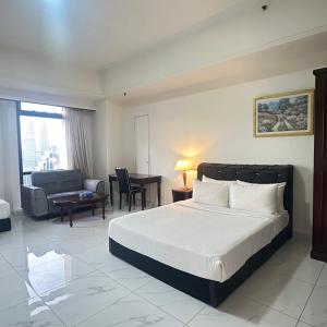 a bedroom with a bed and a living room at Peak Suites At Times Square in Kuala Lumpur