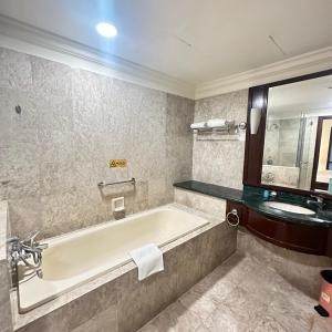 ein Badezimmer mit einer Badewanne und einem Waschbecken in der Unterkunft Peak Suites At Times Square in Kuala Lumpur