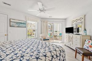 1 dormitorio con 1 cama y ventilador de techo en Shorehaven 16B, en Myrtle Beach