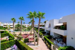 vista para o pátio de um resort com palmeiras em Secreto De La Zenia ID200 em Playa Flamenca