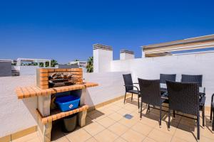 een patio met stoelen en een tafel op een dak bij Secreto De La Zenia ID200 in Playa Flamenca