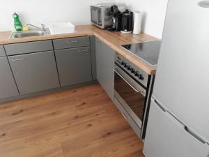 a kitchen with a stove top oven next to a sink at Happy Apartment in Grafenwöhr