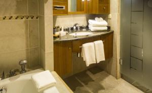 ein Badezimmer mit einem Waschbecken und einer Badewanne in der Unterkunft Park Lake Luxury Hotel in Pucón