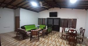 sala de estar con sofá verde y sillas en CASA QUINTA VILLA CECILIA CARMEN DE APICALA, en Carmen de Apicalá