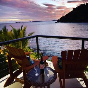 a table with two chairs and a bottle of wine at Lime in de Coconut Villa in Cruz Bay