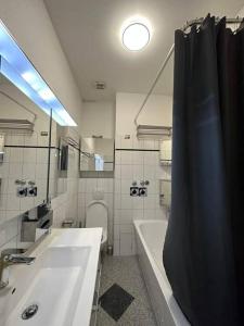 La salle de bains est pourvue d'une baignoire, d'un lavabo et de toilettes. dans l'établissement Business apartment in Berlin, à Berlin