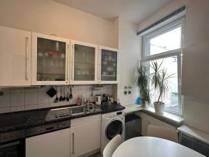 a kitchen with white cabinets and a sink and a window at Business apartment in Berlin in Berlin
