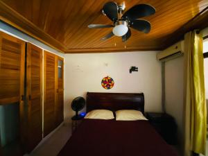 a bedroom with a ceiling fan and a bed at Casa Feliz Hostal in Santa Marta