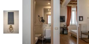 ein Bad mit einem Waschbecken und einem WC in einem Zimmer in der Unterkunft Excellent Trinity Rooms in Rom