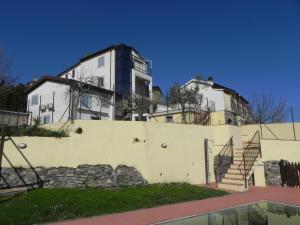 una casa en la parte superior de una pared blanca con un edificio en Villa Borgo degli Artisti Exclusive, en Aulla