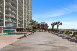 a boardwalk next to a large building with a swimming pool at Ashworth 1809 in Myrtle Beach