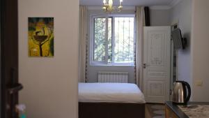 niewielka sypialnia z łóżkiem i oknem w obiekcie Svezhest/Свежесть w mieście Kok-Shoky