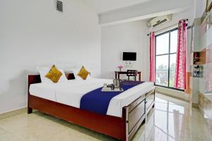 - une chambre avec un grand lit et une fenêtre dans l'établissement SPOT ON Cherai Homes, à Cherai Beach