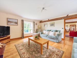 ein Wohnzimmer mit Sofa und Tisch in der Unterkunft Old Rectory Cottages in Aberhafesp