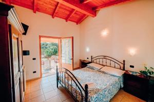 a bedroom with a bed and a sliding glass door at Agriturismo Rocce Bianche - Porticato in Arbus