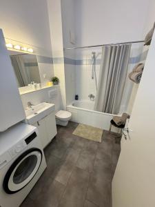 a bathroom with a toilet sink and a washing machine at Vienna Apartment Gutarra II in Vienna
