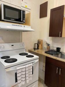 a kitchen with a white stove and a microwave at Cozy Studio with free parking on premises. in Grand Anse
