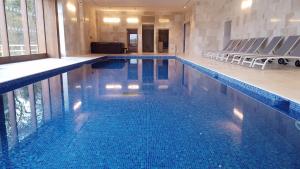 a large swimming pool with chairs in a building at Ox Pasture Hall Hotel in Scarborough