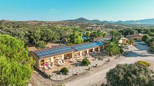 Agriturismo Rocce Bianche - Porticato في أربوس: اطلالة جوية على منزل به لوحات شمسية