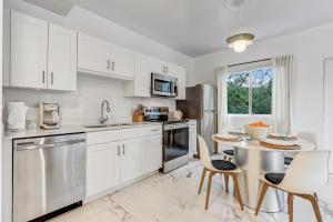 a kitchen with white cabinets and a table and chairs at ArTease5 - stylish, near Wynwood Walls & restaurants in Miami