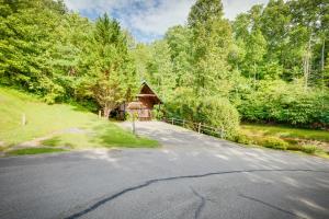 a road leading to a cabin in the woods at Hugs N Kisses Pool Table Hot Tub Pool Table Community Pool Close to Downtown Gatlinburg in Gatlinburg