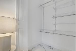 a white bathroom with a toilet and shelves at ArTease5 - stylish, near Wynwood Walls & restaurants in Miami