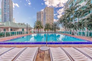 a swimming pool with palm trees and buildings at Sunbeam Plush 2 Story Loft in Miami