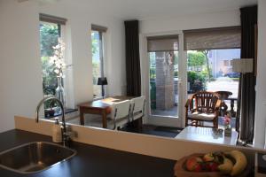 uma cozinha com um lavatório e uma sala de jantar em Magnolia appartement em Vlijmen